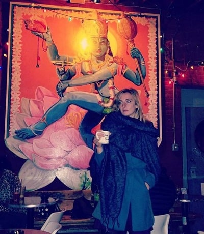 Emily Riedel posing alongside the Lord Vishnus painting